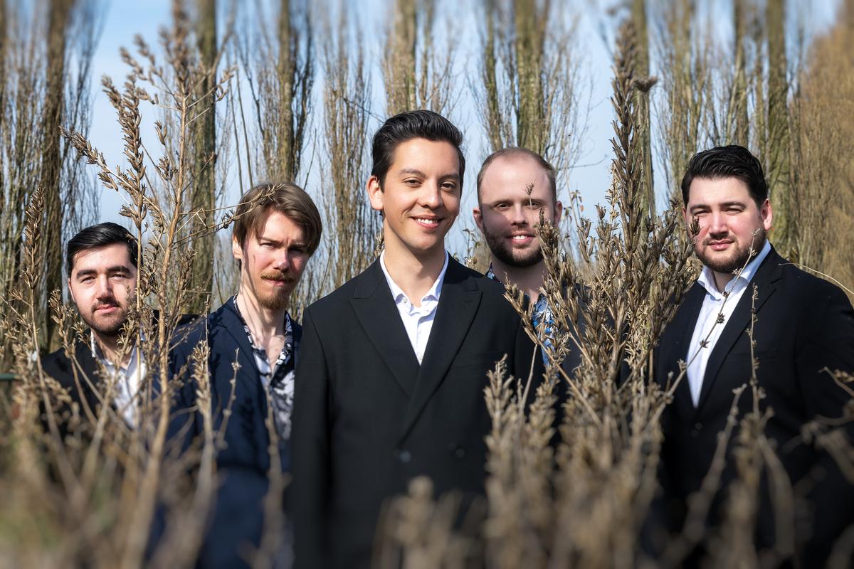 De vijf bandleden van Band on the Run! tussen hoge droge planten